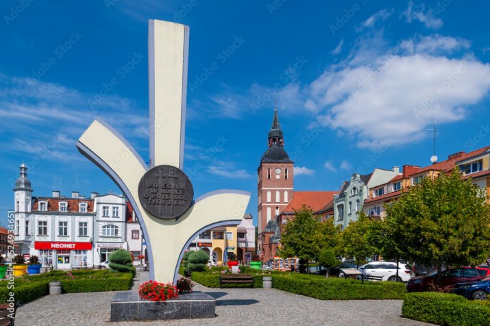 Rynek w Biskupcu z pomnikiem i znakiem Rodła